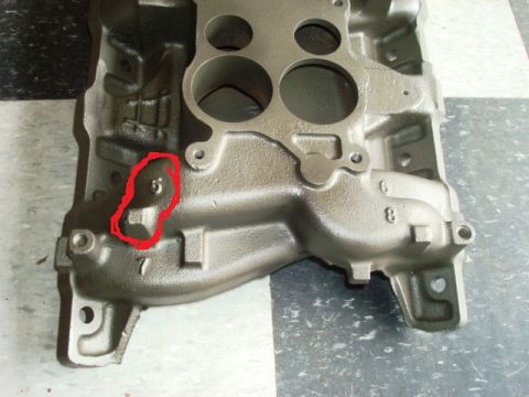1967 Pontiac Grand Prix - Close-up of a cast iron engine intake manifold, showing cast-in numbers and a highlighted area.