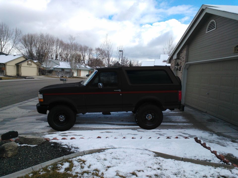 1992 Ford Bronco parked in a snowy driveway, side view