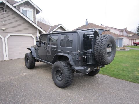 2008 Jeep Wrangler - Modified 2007 Jeep Wrangler 4-door parked in driveway. Features aftermarket wheels and tires.