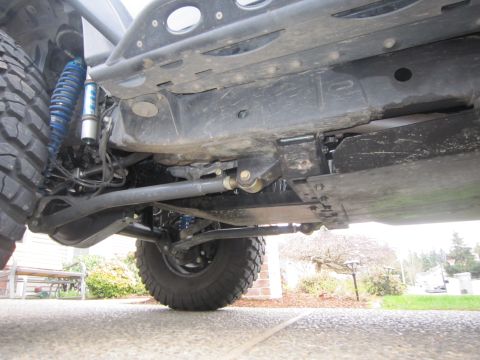 2008 Jeep Wrangler - The undercarriage of a modified Jeep Wrangler shows significant aftermarket modifications, including heavy-duty suspension components.