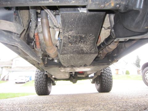 2008 Jeep Wrangler - The undercarriage of a vehicle is captured from a low angle, revealing its mechanical components and off-road tires.
