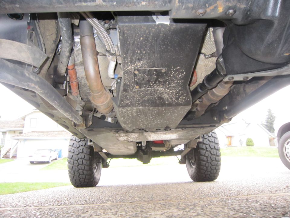 Underside view of a 4x4 vehicle, showing suspension, exhaust, and tires