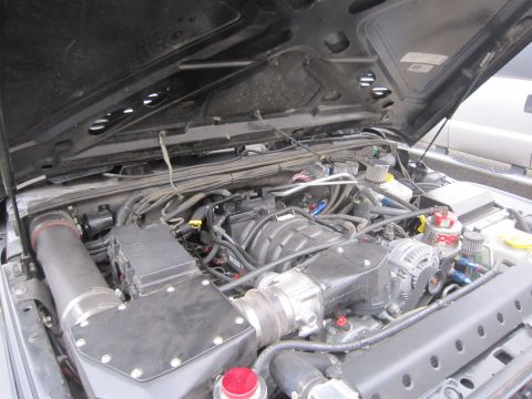 2008 Jeep Wrangler - The engine bay of a Jeep Wrangler shows a supercharger and custom intake system.
