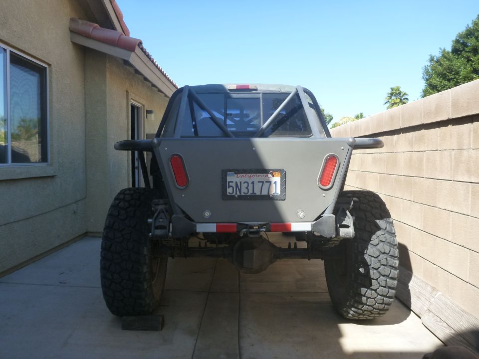 Gray off-road truck rear view, large tires, roll cage, California license plate 5N31771