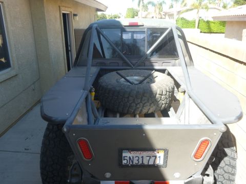 1997 Ford Ranger - This modified pickup truck features a spare tire mounted in the bed, a roll cage, and custom rear bodywork.