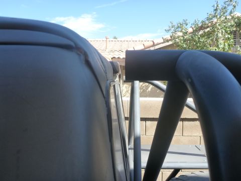 1997 Ford Ranger - Interior view showing a black roll cage against a backdrop of a house and blue sky.