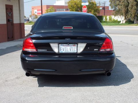 2003 Ford Crown Victoria - Direct rear shot of a black sedan, California EVIL VIC plate, Crown Victoria frame and dual tips.