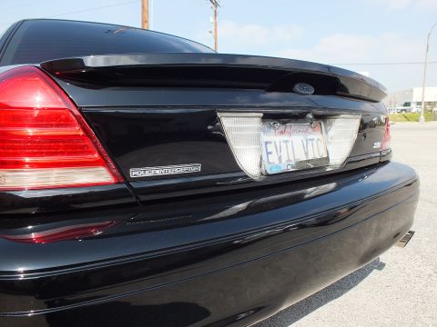 2003 Ford Crown Victoria - Rear of a black Ford sedan: Police Interceptor badge, Ford oval and EVIL VIC plate