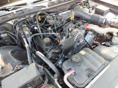 2003 Ford Crown Victoria - Engine compartment overview with intake duct, chrome alternator and plastic coolant tank