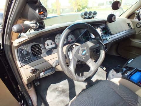 2003 Ford Crown Victoria - Interior view of perforated steering wheel, A-pillar boost gauge and triple-pod gauges on the dash
