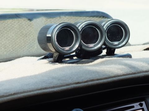 2003 Ford Crown Victoria - Three round black aftermarket gauges in a dash-top pod against a beige dashboard