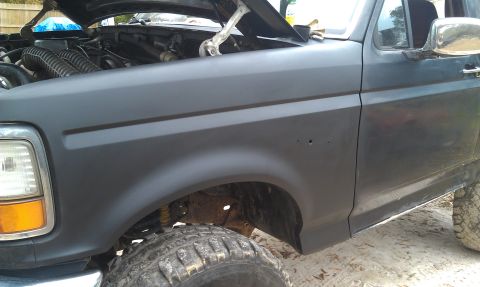 1993 Ford Bronco - The front fender and exposed engine of a 1993 Ford Bronco are visible in this image.