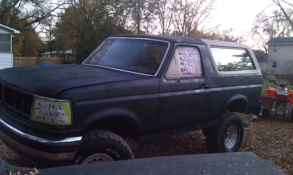 1993 Ford Bronco, matte black, 3q-front view, with taped windows