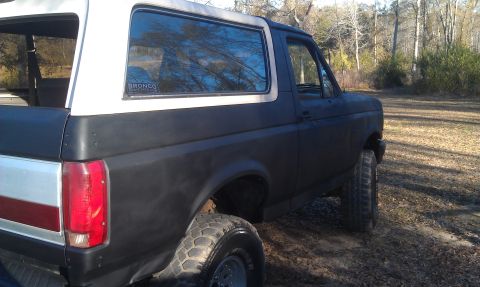 1993 Ford Bronco - This 1993 Ford Bronco is shown from the rear quarter angle, a black lower body and white removable top.
