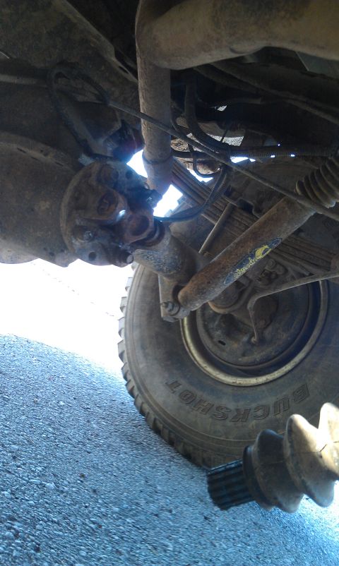 1993 Ford Bronco - Underside view of a vehicle's rear axle and driveshaft with a detached CV joint boot.