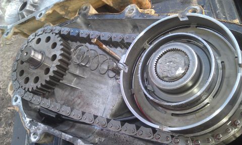 1993 Ford Bronco - Close-up view of the internal workings of a vehicle's transfer case, showing gears and a chain.