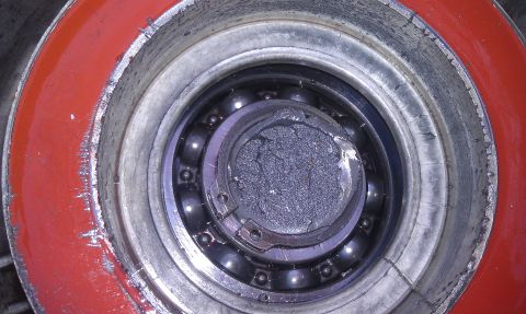1993 Ford Bronco - Close-up view of a severely damaged wheel bearing, showing a broken inner race and accumulated debris.