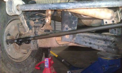 1993 Ford Bronco - Close-up view of a vehicle's suspension and steering components, supported by jacks.