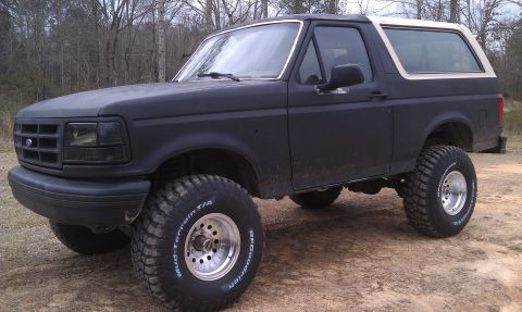 1993 Ford Bronco - This 1993 Ford Bronco features a matte black finish and is equipped with large off-road tires.