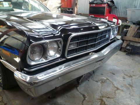 1975 Ford Ranchero - Front view of a black 1977 Ford Ranchero, showing its grille and chrome bumper.