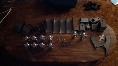 1967 Ford F-250 - A collection of metal components and hardware are neatly arranged on a wooden surface.