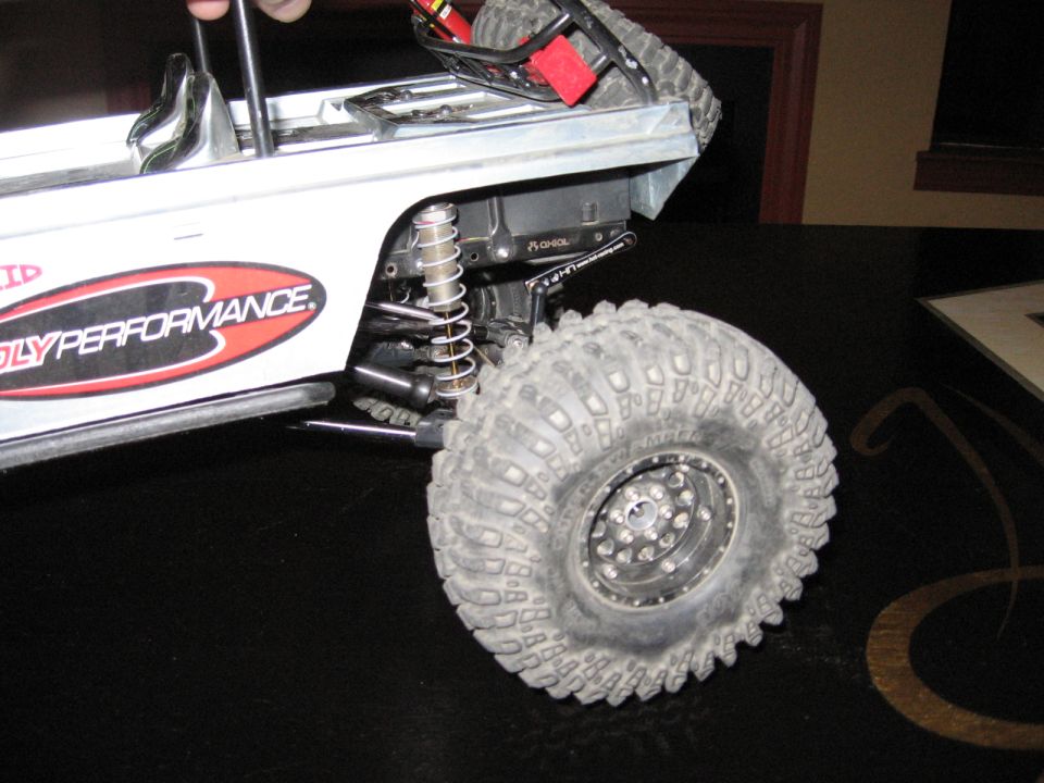 RC rock crawler suspension and wheel with 'OLYPERFORMANCE' decal