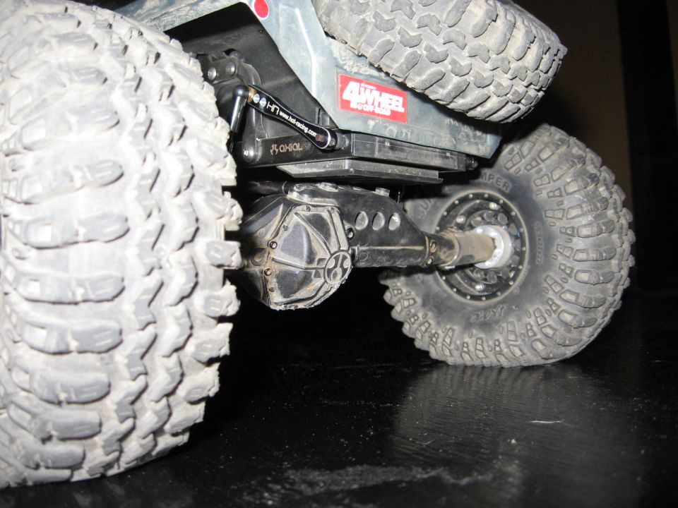 Close-up of a remote control rock crawler's rear axle and large tires