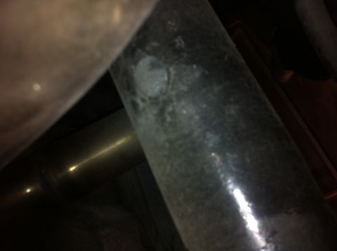 1995 Ford Mustang - Close-up of an exhaust pipe, showing a rivet and the Supermotors.net logo.