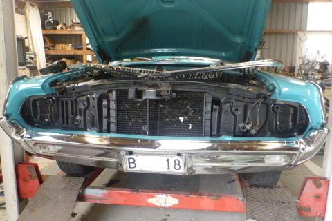 1964 Mercury Monterey - A teal 1964 Mercury Monterey is on a lift with its hood open, revealing the front grille and radiator assembly.