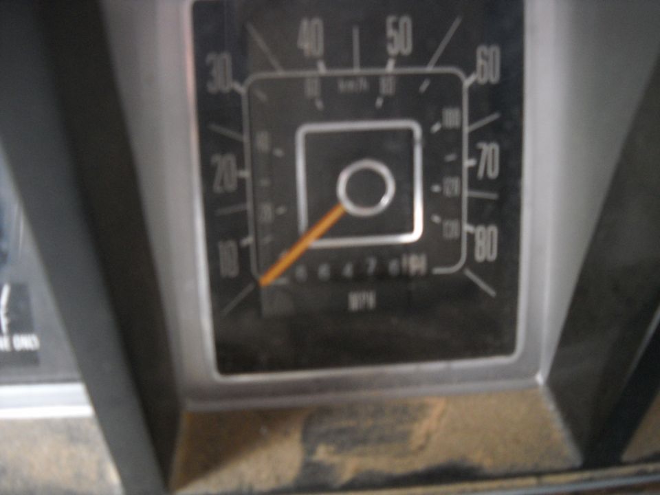 Close-up of a vehicle's dashboard showing a speedometer and odometer. The speedometer reads up to 80 MPH