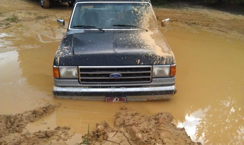 1990 Ford Bronco - This 1990 Ford Bronco is deep in the mud, with only its front end visible.
