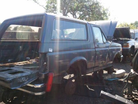 1994 Ford Bronco - Junkyard Bronco missing parts, with another vehicle visible in the background.