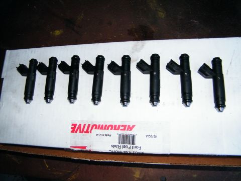 2004 Ford Crown Victoria - Eight fuel injectors are shown on a box that reads 'Ford Fuel Rails'.