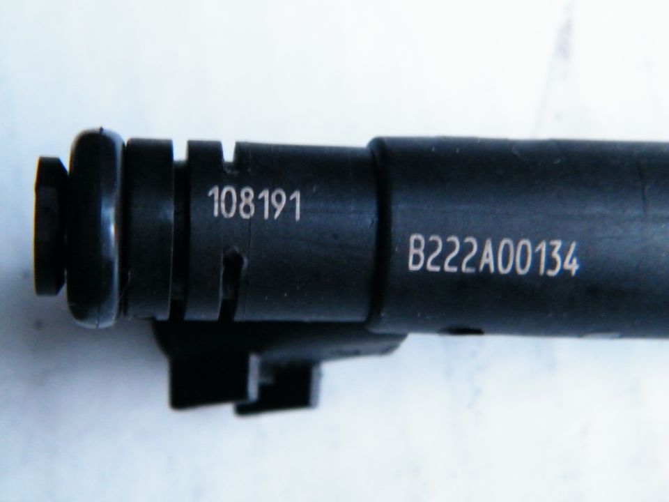 Close-up of a black fuel injector with part numbers 108191 and B222A00134 stamped on it