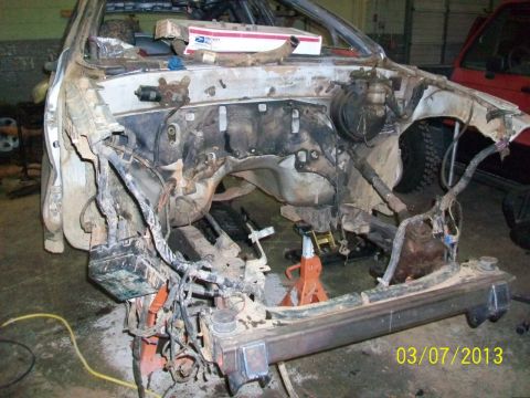 1999 Isuzu Vehicross - Vehicle chassis undergoing disassembly, with engine bay and front frame exposed.