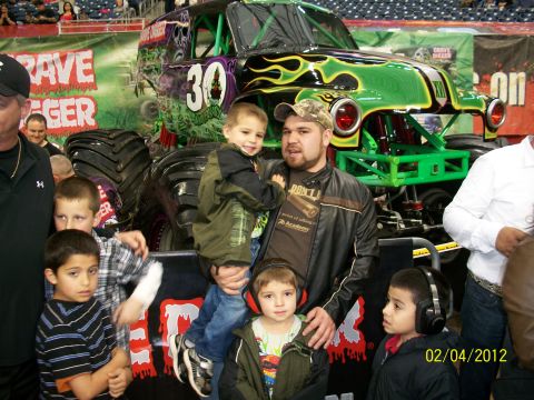 1989 Ford Bronco - People pose in front of the Grave Digger monster truck at an event.