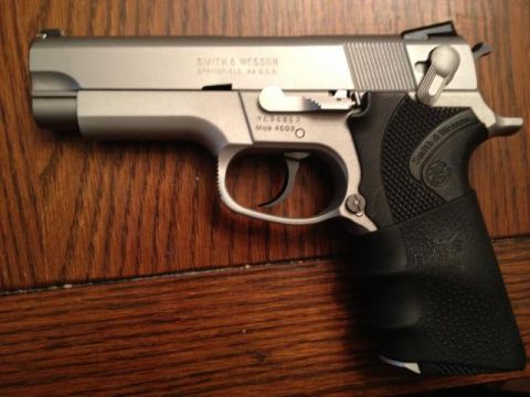1995 Ford Bronco - A Smith & Wesson Model 4006 pistol is shown resting on a wooden surface.