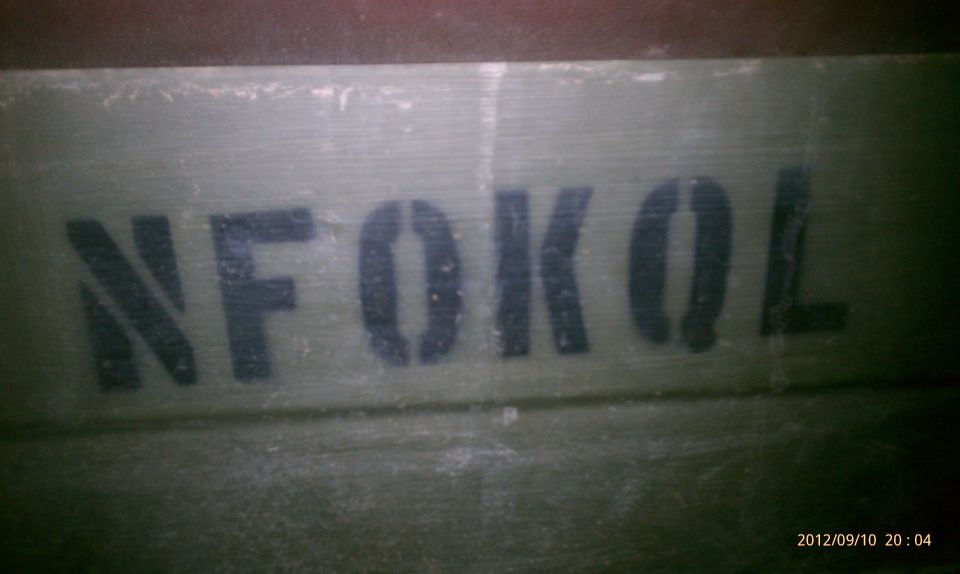 Stencil text "N F O K O L" on a green surface