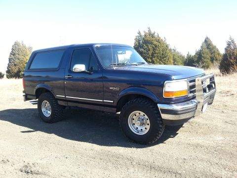 1995 Ford Bronco - 1995 Ford Bronco in blue with a chrome bull bar and aftermarket wheels.