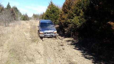 1995 Ford Bronco - This 1995 Ford Bronco navigates a muddy, off-road path through a wooded area.