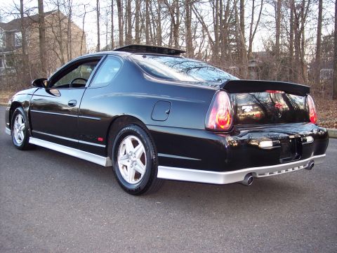 2002 Chevrolet Monte Carlo - A black Chevrolet Monte Carlo is parked on an asphalt surface with trees in the background.