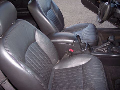 2002 Chevrolet Monte Carlo - The interior of a 2002 Chevrolet Monte Carlo features black leather bucket seats and a center console with a gear shifter.
