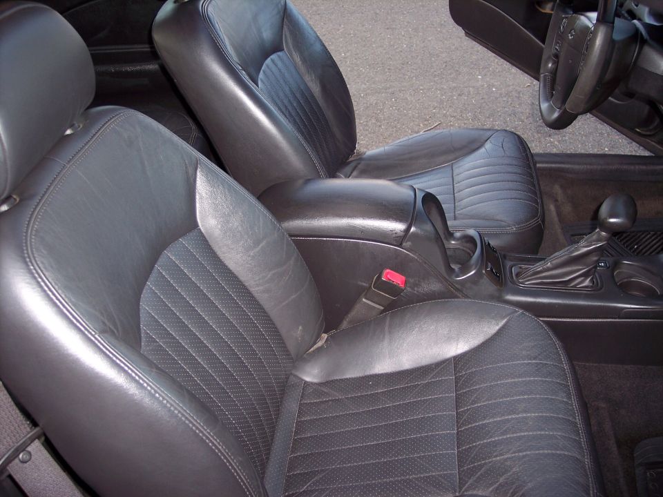 Interior of a 2002 Chevrolet Monte Carlo showing black leather bucket seats and center console