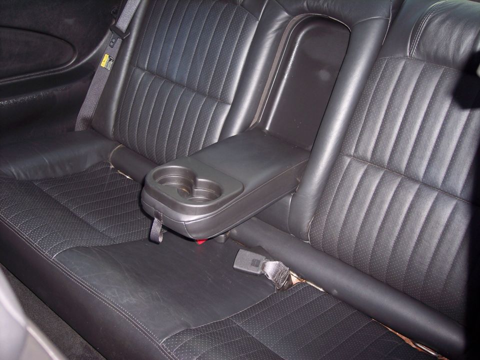 Black leather rear seats with center console cup holder in a 2002 Chevrolet Monte Carlo