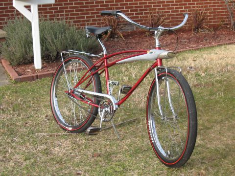 1994 Ford Bronco - A vintage-style red bicycle with chrome accents sits on a grassy lawn in front of a brick building.