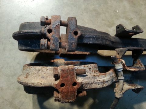 1995 Ford Bronco - Close-up view of two rusty automotive parts, likely from a vehicle's suspension or drivetrain, bolted together for display or sale.