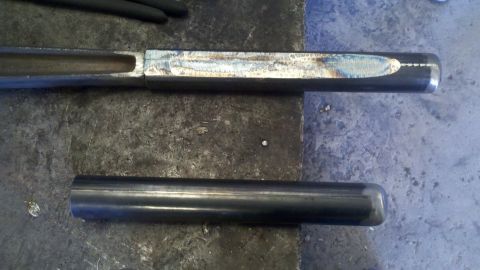 1996 Ford Bronco - Close-up of metal parts on a workbench, possibly for automotive repair or fabrication.