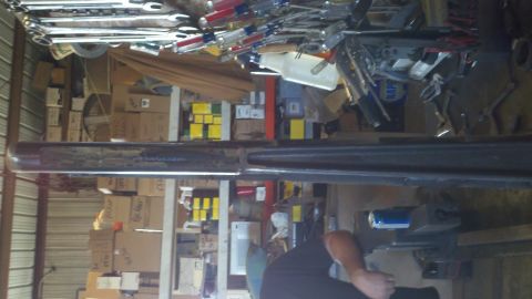 1996 Ford Bronco - A cluttered garage interior is filled with shelves packed with tools and cardboard boxes.