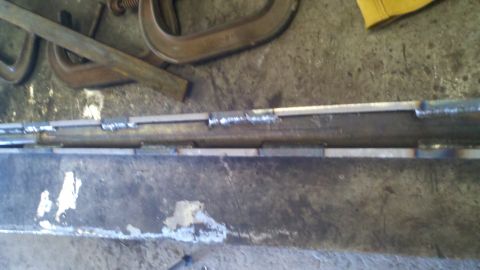 1996 Ford Bronco - A close-up view of a metal frame with multiple welds and clamps, suggesting fabrication or repair work.