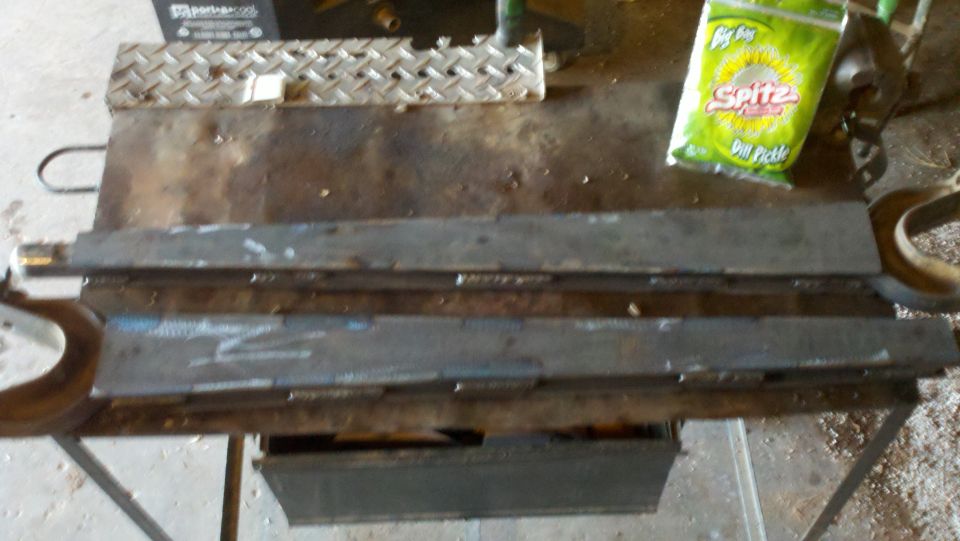 Metal parts and a bag of Spitz Dill Pickle chips on a workbench